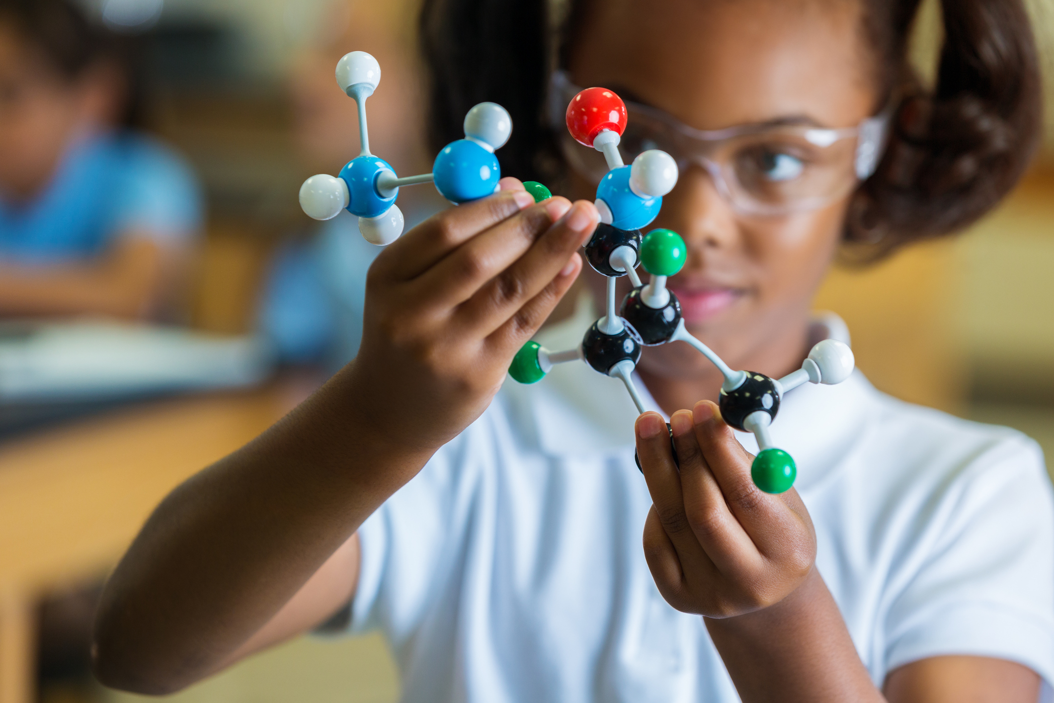 Private elementary school girl examines molecular structure